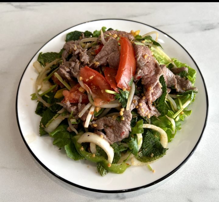 Ensalada de ternera picante (brotes de soja, cebolla, pimiento, tomate, cilantro, menta, cacahuete y chile de la casa)